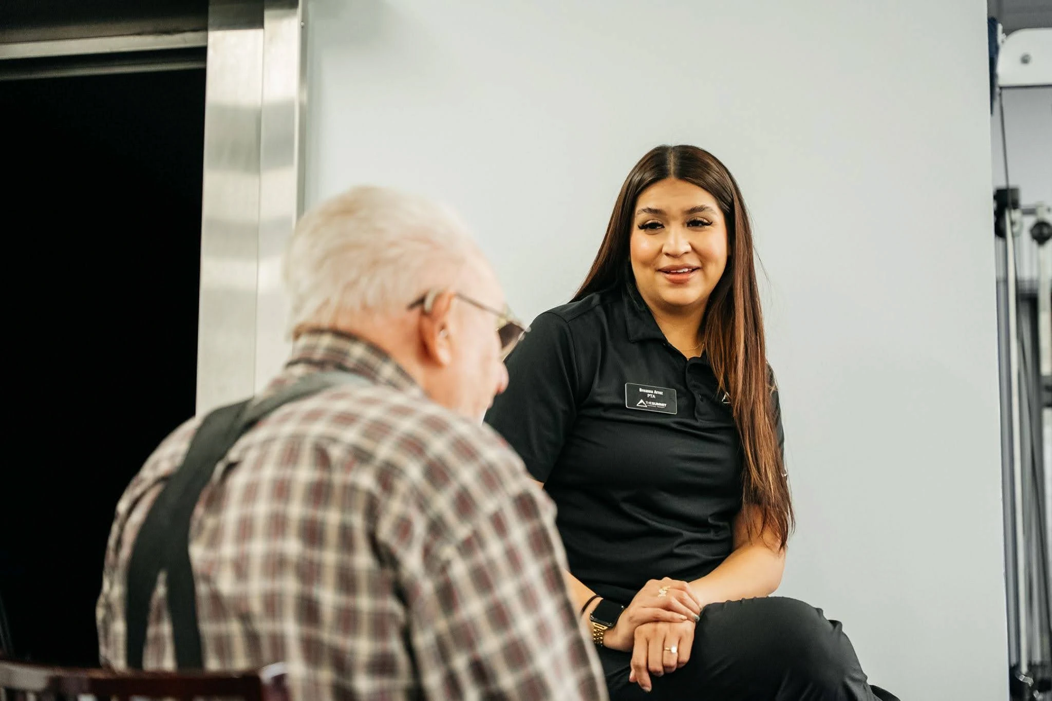 Summit PT physical therapist assistant talking with a senior patient during a clinic visit